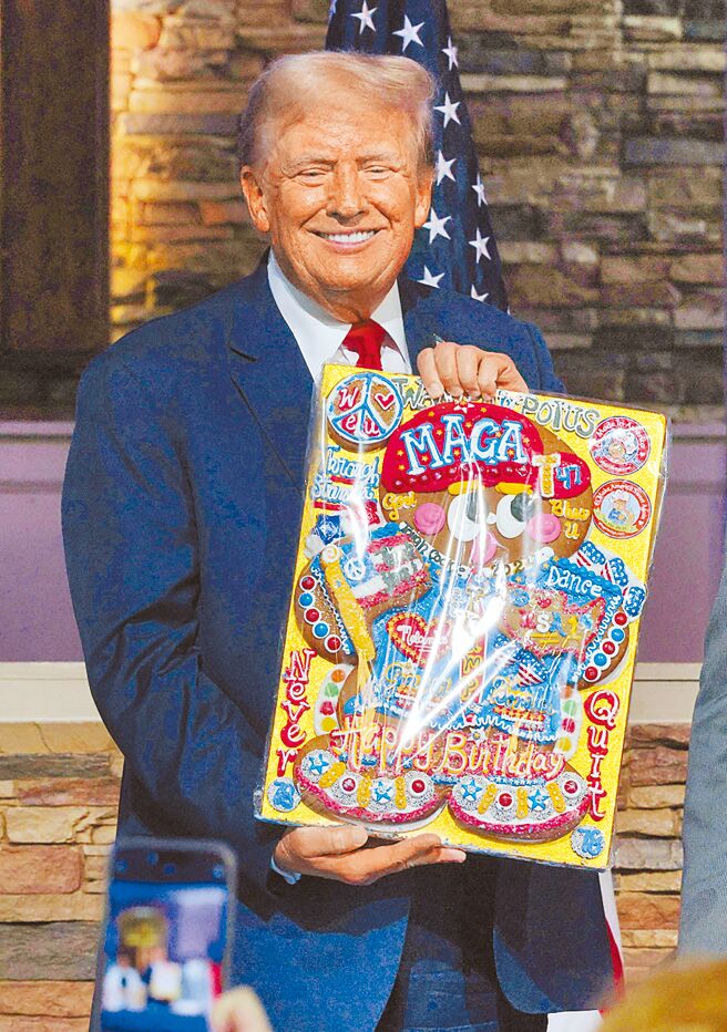 共和党总统候选人川普暗示可能会任命非裔共和党籍眾议员唐纳兹为竞选搭檔。图为川普手持一份支持者送给他的生日礼物。（路透）