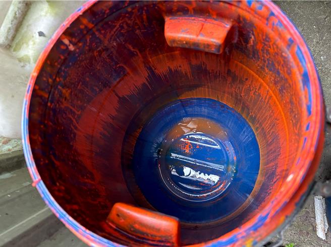 稽查人員在廠內發現裝成紅色染料的塑膠桶。（新北市環保局提供）