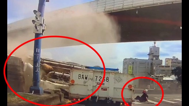 水泥車翻覆，差點壓到男騎士，還好騎士驚險躲開。（翻攝畫面）