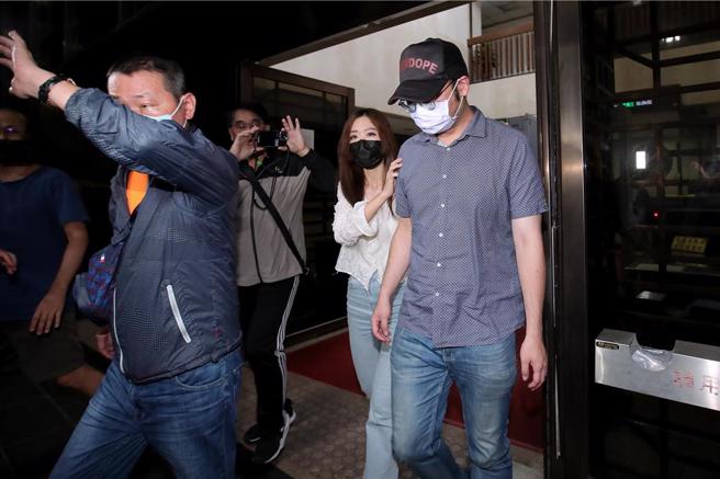 蒋欣璋（右一）步出地检署时，戴着口罩、压低帽沿，不愿透露任何案情。（黄世麒摄）