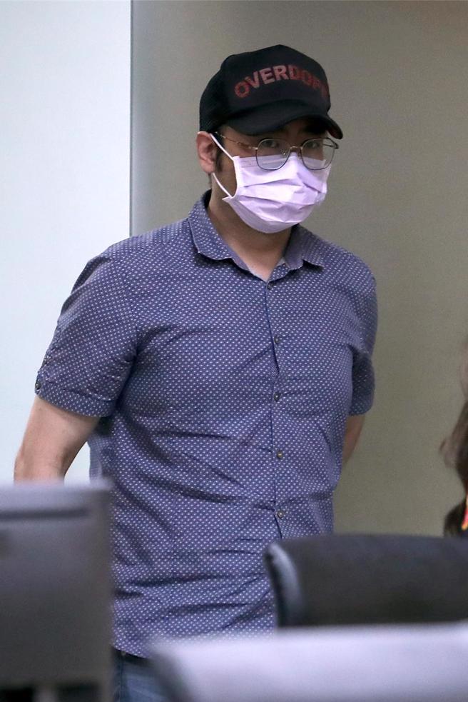 蒋欣璋步出地检署时，戴着口罩、压低帽沿，不愿透露任何案情。（黄世麒摄）