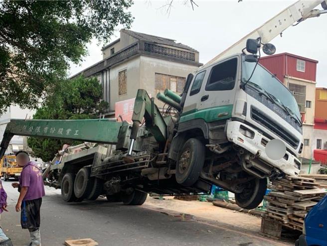 金门地区昨日下午一辆水泥灌浆车在金城市区施工时，疑因路面塌陷导致车辆倾倒、车头悬空「翘独轮」，险象环生。(图／民眾提供)