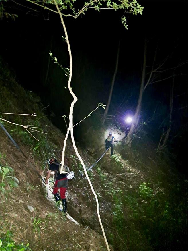 地面部隊上山協助左腳受傷李男下徹，直升機空勘發現遭溪水沖走的洪男，將大體吊掛下山，交由檢警相驗。（南投縣政府提供／楊靜茹南投傳真）