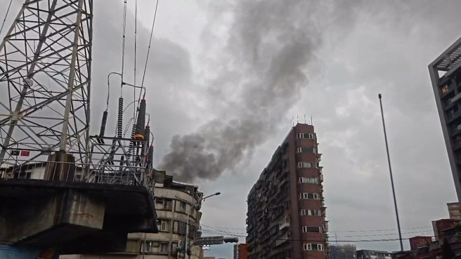 中和胜利路巷弄内的公寓，后侧不断冒出黑烟。（翻摄画面）