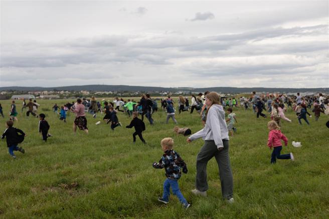 在场大小朋友开心地衝向机场草地，拾取降落的糖果物资。（取自DVIDS网站）