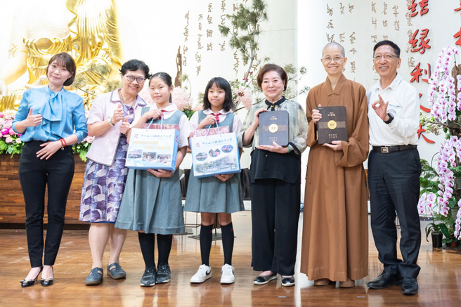 佛光山中區總住持暨均頭董事長覺居法師（右二）、佛光山均頭總校長吳榕峯(右一)帶領師生上台致贈禮品，感謝陳淑芳老師(右三)對均頭孩子們的照顧和教導。(圖/佛光山惠中寺提供)