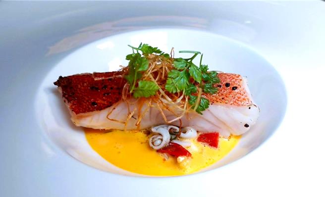 「紙包魚」選用季節魚種紅鰷石斑，肉質細緻鮮甜，與季節時蔬一起燜蒸，醬汁為發酵過的胡蘿蔔製成法式奶醬，整體風味可感受到蔬果清甜與魚肉鮮美。(陳韻萍攝)