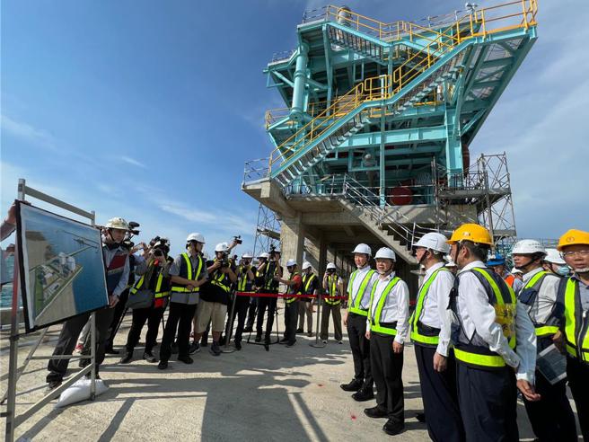 行政院院长卓荣泰视察第三座液化天然气接收站工程，现场听取工程简报（后方为卸料臂）。图／中油提供