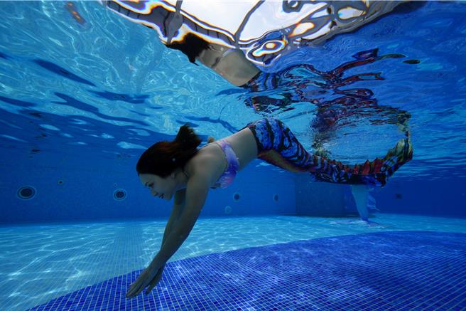 每周六下午4點半至5點半，大地酒店露天泳池畔會有美人魚真人表演秀，入住旅客可近距離與美人魚合影留念，或是在在水中互動及共舞。(大地酒店提供)