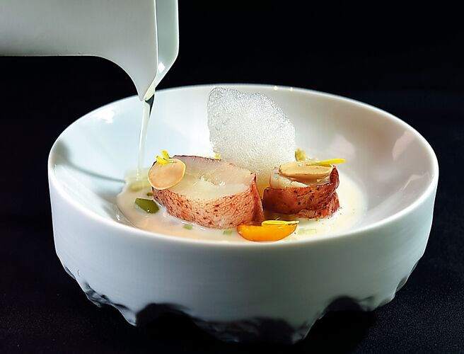 〈龍蝦／西班牙冷湯／燈籠果〉碗底白湯，是杏仁大蒜湯。透明的湯是用番茄、小黃瓜、紅燈籠椒與洋蔥等食材作的澄清湯。圖／姚舜