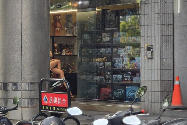 从照片上可见，身份疑为店面板娘的女子翘着一双修长美腿，比例堪称完美。（图 / 翻摄自脸书社团「路上观察学院」）