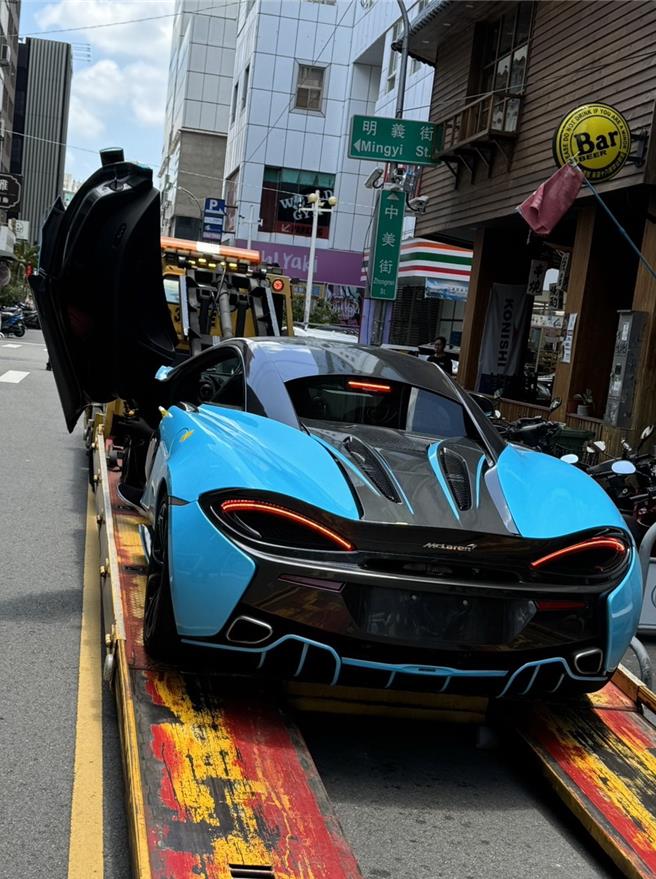 中市餐酒馆老板锺士豪23日凌晨驾驶逾千万元的炫蓝麦拉伦超跑违停，遭警拦查，他坦承喝酒，但不配合酒测，经警开单告发；拖吊车到场车因车未开锁无法拖吊，警方漏夜通知不到车主，直接住处才找到锺处理，拖吊业者小心翼翼将车拖走。（民眾提供／陈淑芬台中传真）