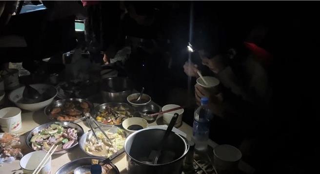 小琉球6月15日晚間停電，原本家族聚餐日的李姓鄉民想吹著冷氣大啖美食，結果戴頭燈吃帝王蟹，沒冷氣吹只能搧扇子。（李姓鄉民提供／羅琦文屏東報導）