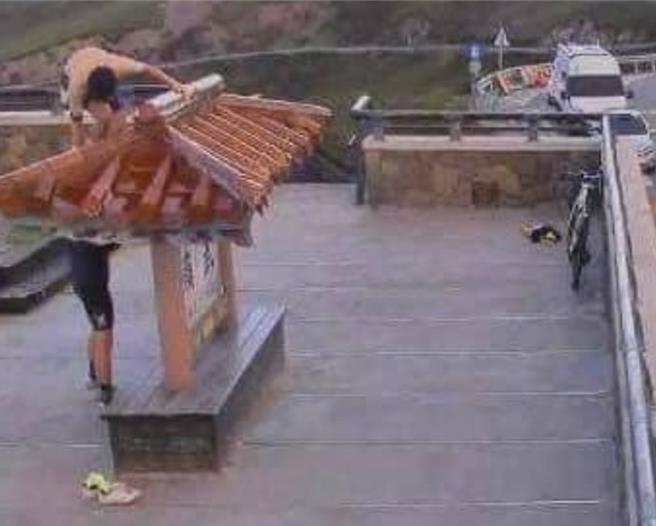 单车男昨（23日）傍晚6时许攀上武岭亭屋顶拍照，过程全遭武岭亭镜头君记录下来。（翻摄脸书「中横路况交通资讯站」／杨静茹南投传真）