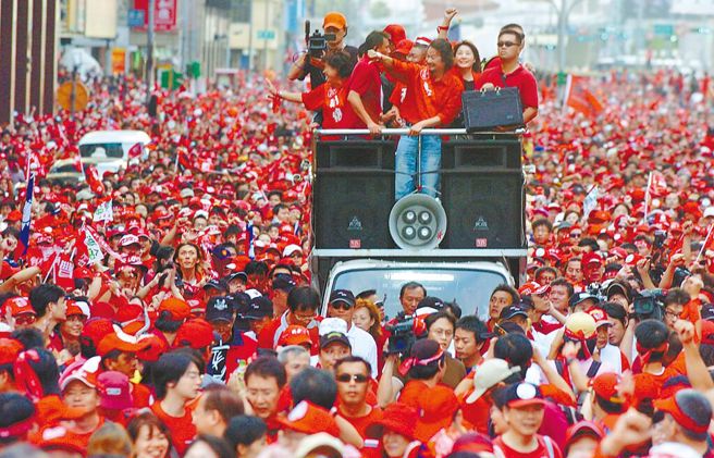 2006年10月，反貪腐總部發起「天下圍攻」百萬人倒扁大遊行，紅衫軍總指揮施明德站在戰車上率民眾比著倒扁手勢。（資料照）