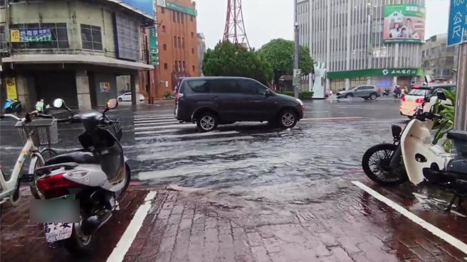 嘉义市今天下午暴雨，中山路、文化路、喷水圆环周边积水漫流过人行红砖道。（廖素慧摄）