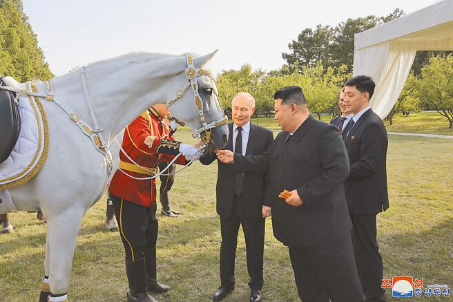 北韩领导人金正恩（前右）和俄罗斯总统普丁（中），于19日在平壤锦绣山国宾馆的花园中谈天。（美联社）