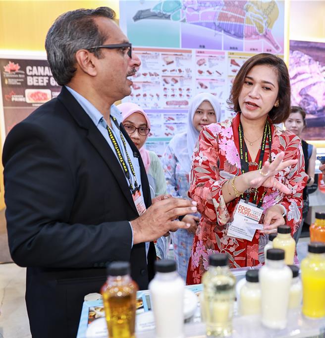 馬來西亞駐台首席代表Ms. Aznifah Ghani（右）在台北國際食品展上，推廣馬國特色食品。（圖／羅永銘攝）
