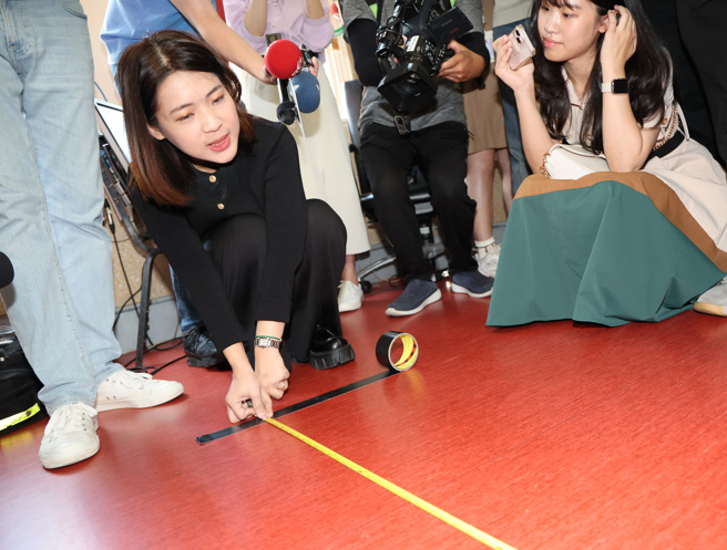 民進黨立法院黨團26日在黨團會議室舉行「聲請國會擴權法案釋憲」記者會時，國民黨立委徐巧芯拿出捲尺在場外量出100公分距離聆聽，聲援同黨立委陳玉珍前一天在外聆聽時遭民進黨控訴盯哨的口角衝突。（姚志平攝）