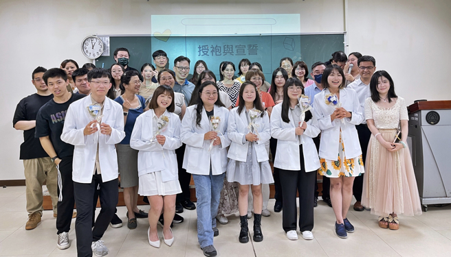 為即將至醫療院所進行心理師實習的7位碩士學長姐們獻上驚喜祝福，心理學系系主任林緯倫領銜師長親自為臨床心理實習的碩士生們授白袍，期待他們在未來為心理專業永續發展努力。(照片/佛光大學提供)