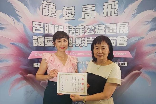 「让爱高飞 吕阿福·糕菲·公益画展暨让爱高飞 影片发布会」于6月26日在糕菲庇护工场举办，糕菲主任王淑真(右)颁发感谢状给导演华慧莹(左)。图／糕菲庇护工场提供