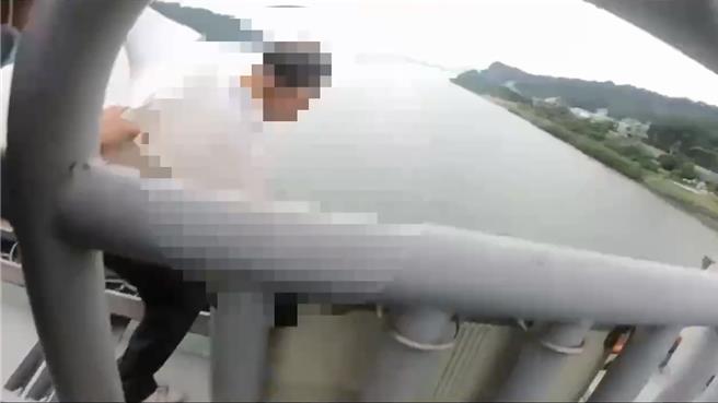 白衣老翁在关渡桥想要轻生，警员在千钧一髮之际将他抱住，从鬼门关救回。（淡水警分局提供）