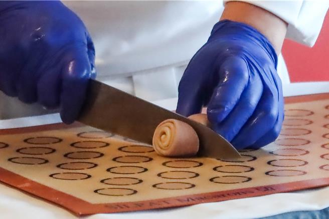 点心坊的蛋黄酥「橙月礼盒」有着马卡龙色千层酥皮，日前发表会上，主厨示范如何做千层酥皮。（粘耿豪摄）