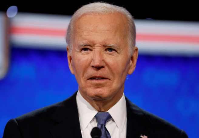 美國總統拜登27日晚參加首場總統候選人電視辯論的神情。（路透）