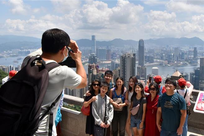 图为游客在香港太平山顶拍摄合影。（摘自新华社）