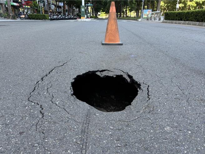高雄市今日下午3时许，在85大楼前的新光路与自强路口突冒出圆形坑洞。（民眾提供／杨舒婷高雄传真）