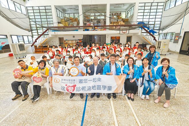和泰大金连续10年与喜憨儿基金会合作偏乡送爱活动，26日赴宜兰大里国小学童们合照，和泰大金空调董事长王玄郎（前排右五起）、大里国小校长郑适庆与喜憨儿基金会总监武庭芳。图／和泰大金空调提供