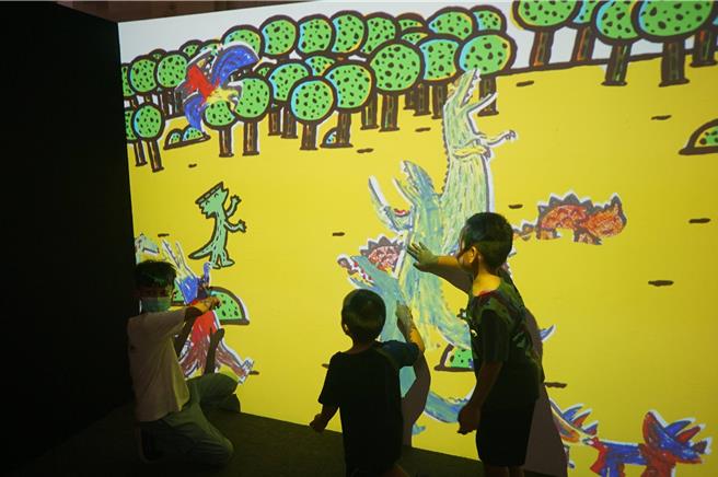 小朋友与数位动画恐龙互动，开心不已。（罗琦文摄）