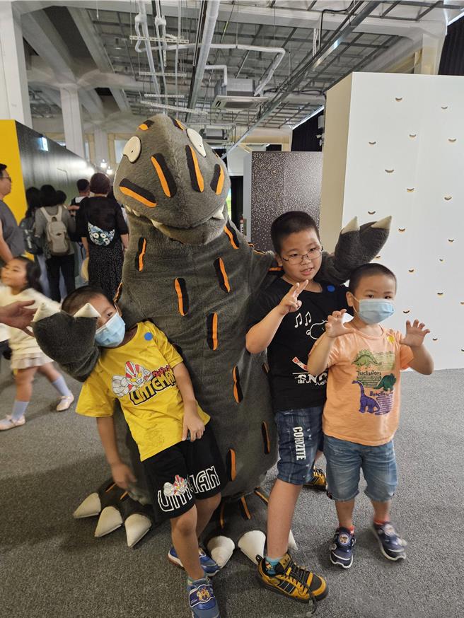 小朋友开心和恐龙合照。（罗琦文摄）