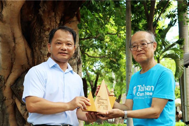 林业署嘉义分署副分署长李定忠（左）将以台湾珍贵树种制成的感谢奖座送给台湾世界遗产登录应援会理事片木裕一（右）。（吕妍庭摄）