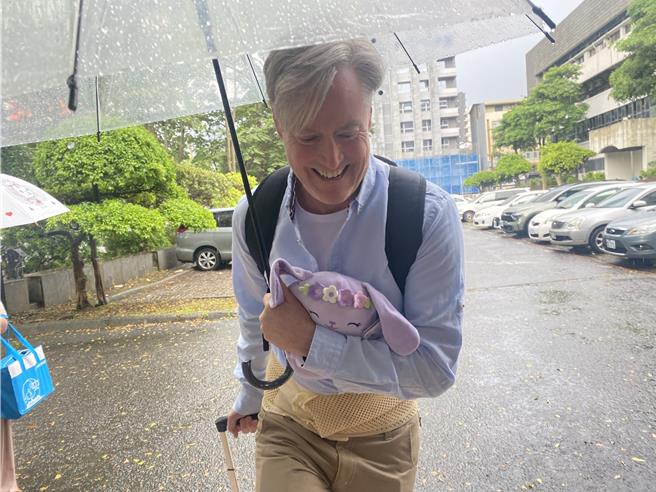 夏克立手抱紫色公仔到庭，并称不能说什么不然会被关到监狱。（李文正摄）