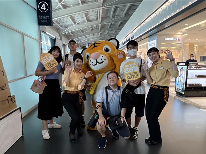 旅客們興奮地和虎將及虎妞們拍照留念。（台灣虎航提供／陳祐誠台北傳真）
