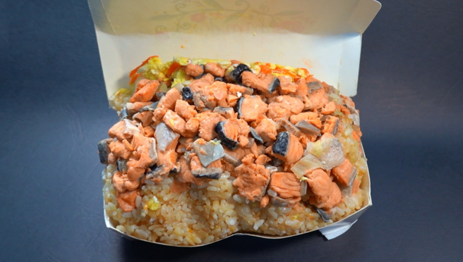 万华巨无霸炒饭，鲑鱼堆成山，满到盒子盖不上。(吴振煌拍摄)