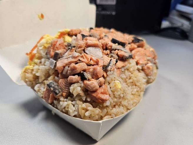 巨无霸炒饭鲑鱼块和饭量超过便当盒。(游定刚拍摄)