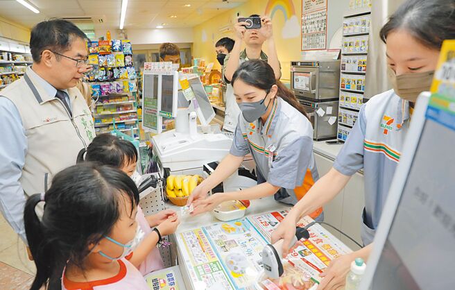 台南市政府社會局提供弱勢兒少寒暑假使用的紙本愛心餐食券，今年暑假改為使用市民卡或一卡通數位票卡兌餐。市長黃偉哲（左）視察兒少使用情形。（社會局提供／洪榮志台南傳真
