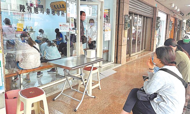台南新冠肺炎疫情持续上升，卫生局统计上周门急诊就诊计1万1310人次，较前1周上升23％。图为诊所内外都有不少等候看诊的民眾。（曹婷婷摄）