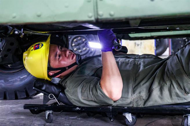  梁俊贤细心缜密确认车辆管路是否渗漏、束环是否确实锁紧。（记者杨乔琳摄）