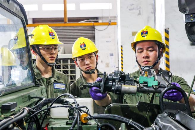 　煞车总泵为车辆制动力关键，梁俊贤（右1）指导同仁在安装时，要注意各项零附件皆妥当。（记者杨乔琳摄）