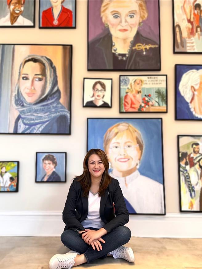 高市观光局长高闵琳于世界女性政治领袖肖像画墙前留影。（高市观光局提供）