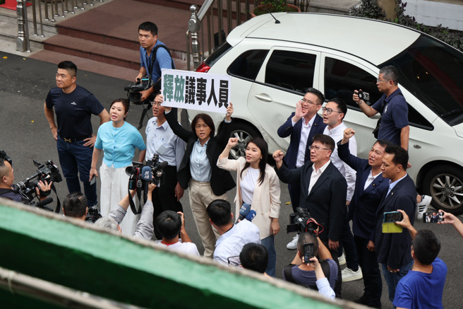 立法院内政委员会4日审查「公职人员选举罢免法部分条文修正草案」等案，民进党占领主席台暴发蓝绿衝突与空转，召委高金素梅下午宣布改换到群贤101会议室，但议事人员遭民进党留在原会议室内，并由民进党立委把关，国民党立委在会议室楼下高举「释放议事人员」标语。（姚志平摄）