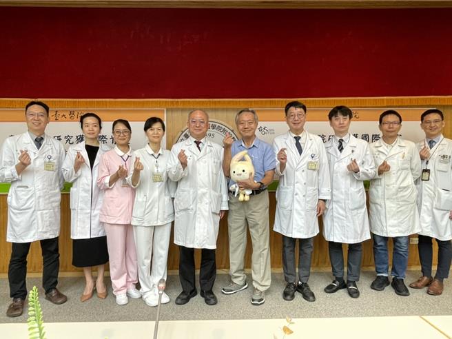 陳先生（中）現身分享，自己父親因下肢傷口久治不癒，到台大醫院動手術後續接受遠距照護，改善不願出門，生活狀態和以前相比進步許多，院長吳明賢（中）致贈台大醫院吉祥物醫寶祝賀。（鄭郁蓁攝）