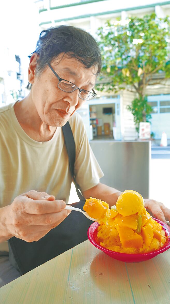 台南市玉井區3日氣溫一度達37.8度，專程到玉井吃芒果冰消暑的日本觀光客前川泰一郎直呼好吃。（寶智華攝）