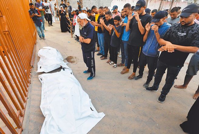 以军与哈玛斯之战造成伤亡。 图为民眾为丧命的巴勒斯坦人默哀。（资料照／路透）