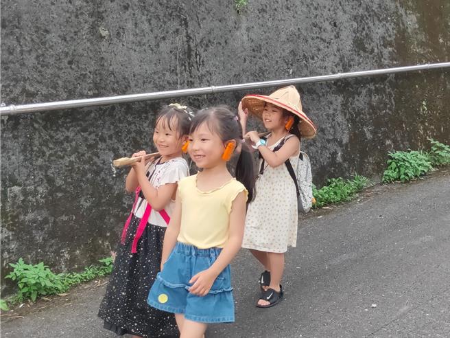海委會推出「金山蹦火漁村體驗活動」，圖為孩童體驗魚路古道以前擔魚的情形。（海委會提供／林瑞益高雄傳真）