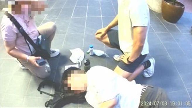 男子突然昏倒倒地，保大员警与救护人员赶紧将他送医。(翻摄照片／林郁平台北传真）