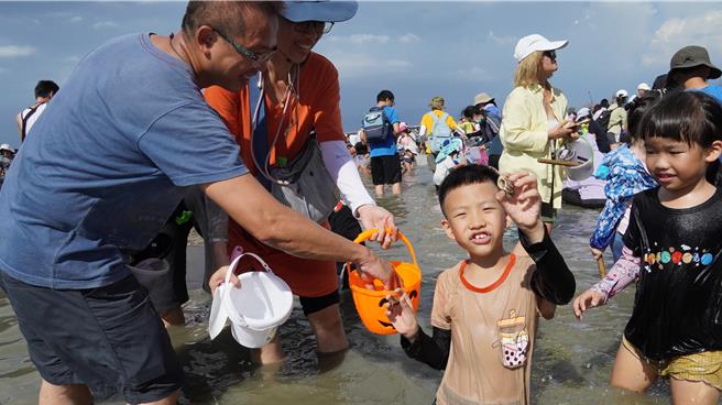 挖到文蛤的小朋友开心不已。（宝智华摄）